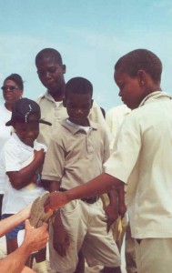 Scouth Caicos schoolchildern on Long Cay examine iguana before release
